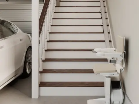 Schmaler Treppenlift an einer geraden Treppe neben einer Garage